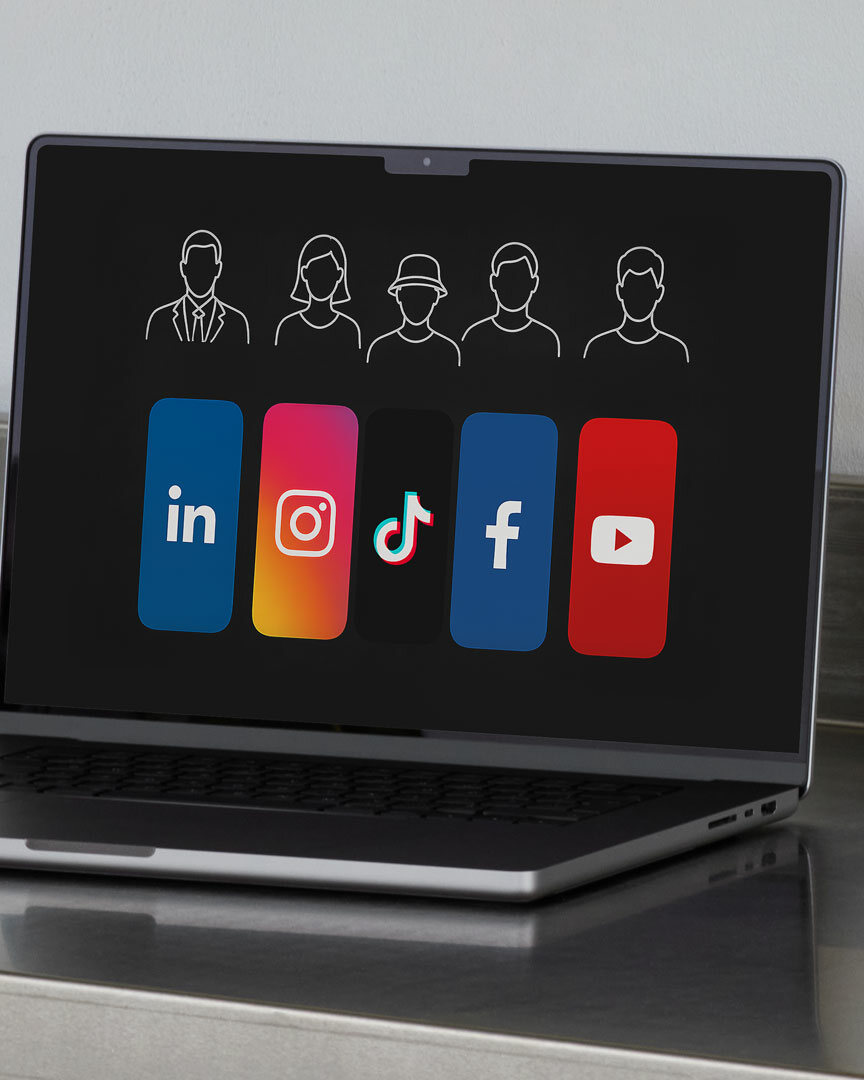 Silberner Laptop auf Metallablage steht aufgeklappt. Zu Sehen ist der Monitor des Laptops, auf dem ist eine Grafik zu erkennen, die die Social Media Plattform Logos von Linkedin, Instagram, TikTok, Facebook und YouTube zeigt. darüber ist eine Schemenhafte Darstellung der jeweiligen möglichen Zielgruppen in Iconform zu erkennen.